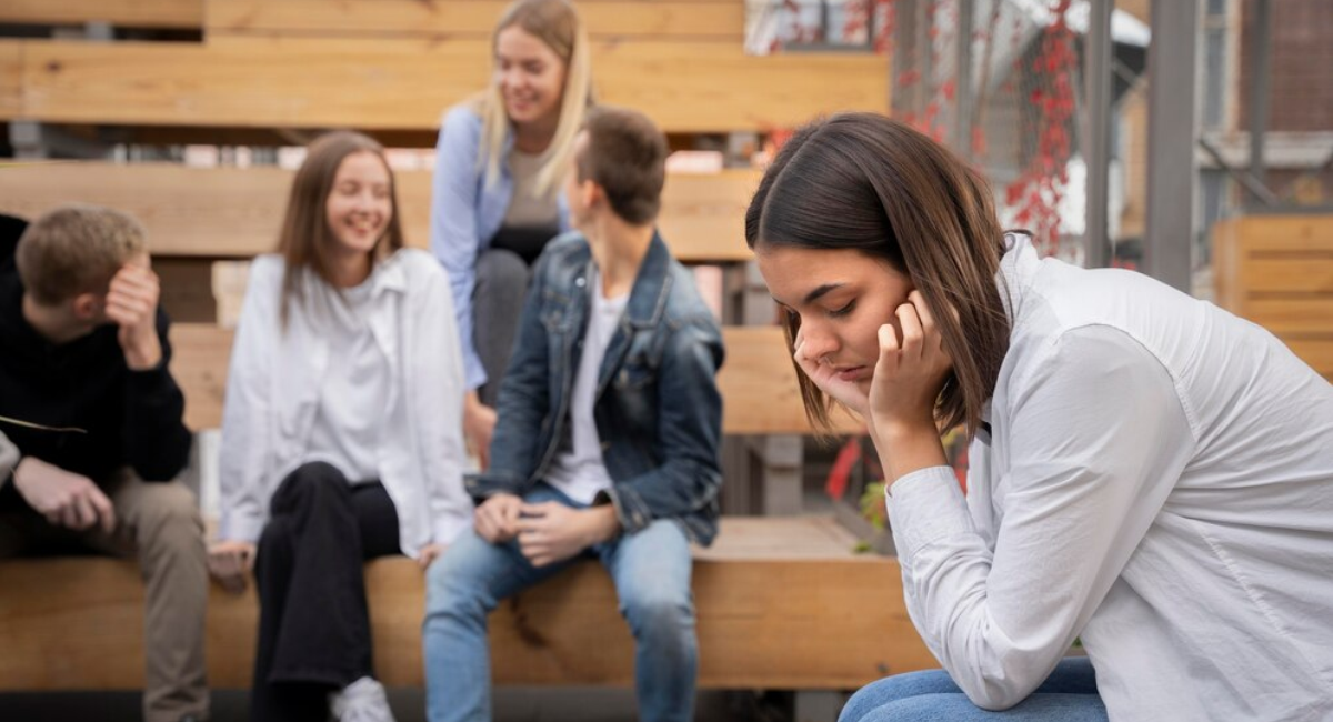 Anxious woman experiencing severe distress and avoiding a nearby social gathering, representing the urgent need for social anxiety disorder treatment in Mohali.
